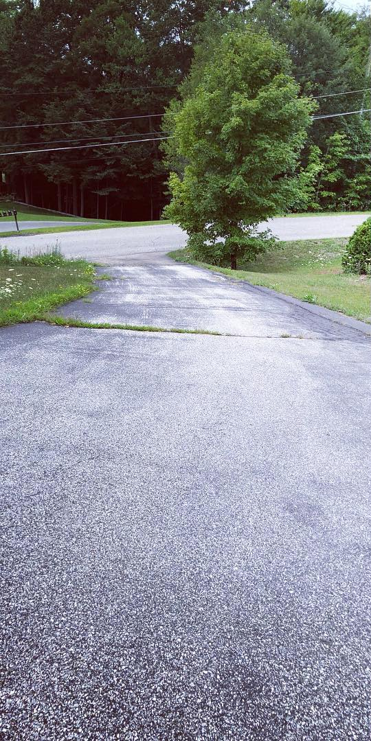 Worn asphalt driveway before paving